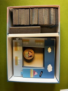 Contenu de la boîte de Draculotte : jeu solo qui mélange taquin / casse-tête et jeu de plateforme rétro. Des tuiles, un module à assembler comme un puzzle